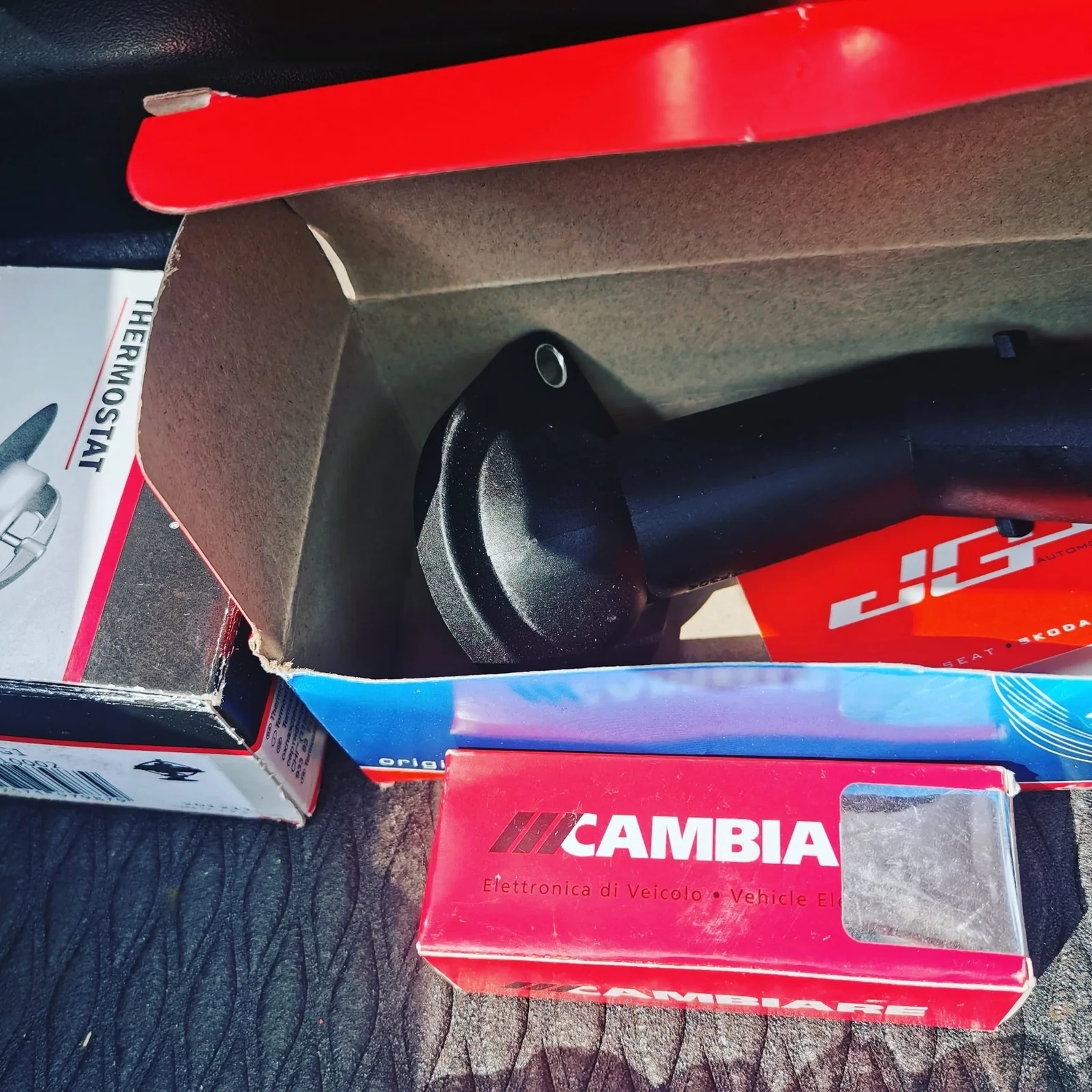 Replacement thermostat and coolant housing parts in their workshop packaging